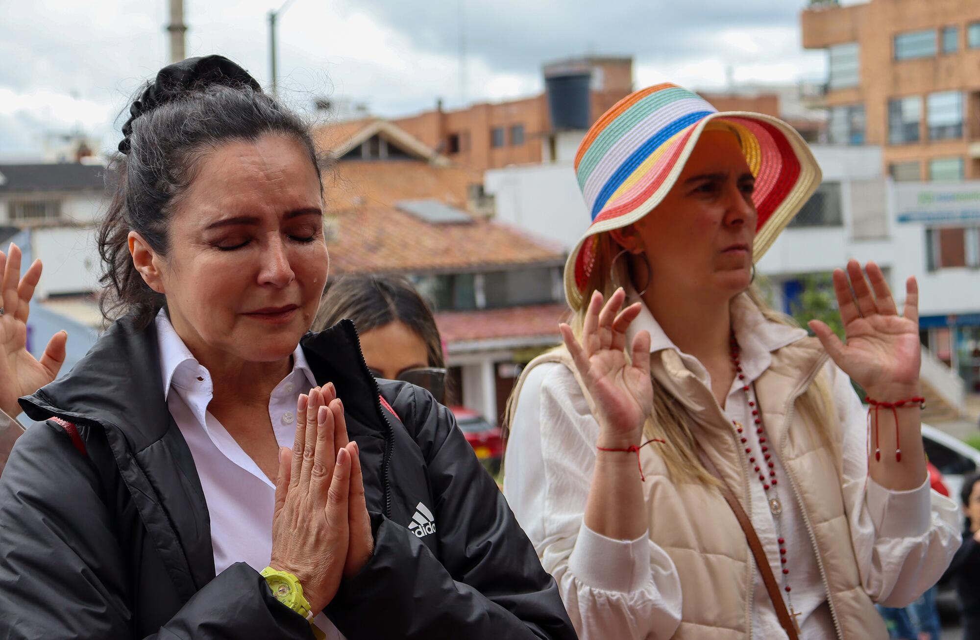 Simpatizantes de Miguel Uribe Turbay rezan fuera de la clínica.